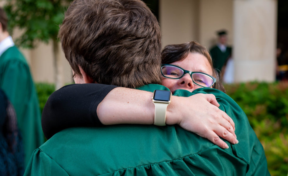 Lauren Rodriguez gives her son Greyson a congratulatory hug after he accepted his high school diploma at a commencement ceremony in early June. The 17-year-old graduated a year early after bullying prompted him to switch into an online school. 