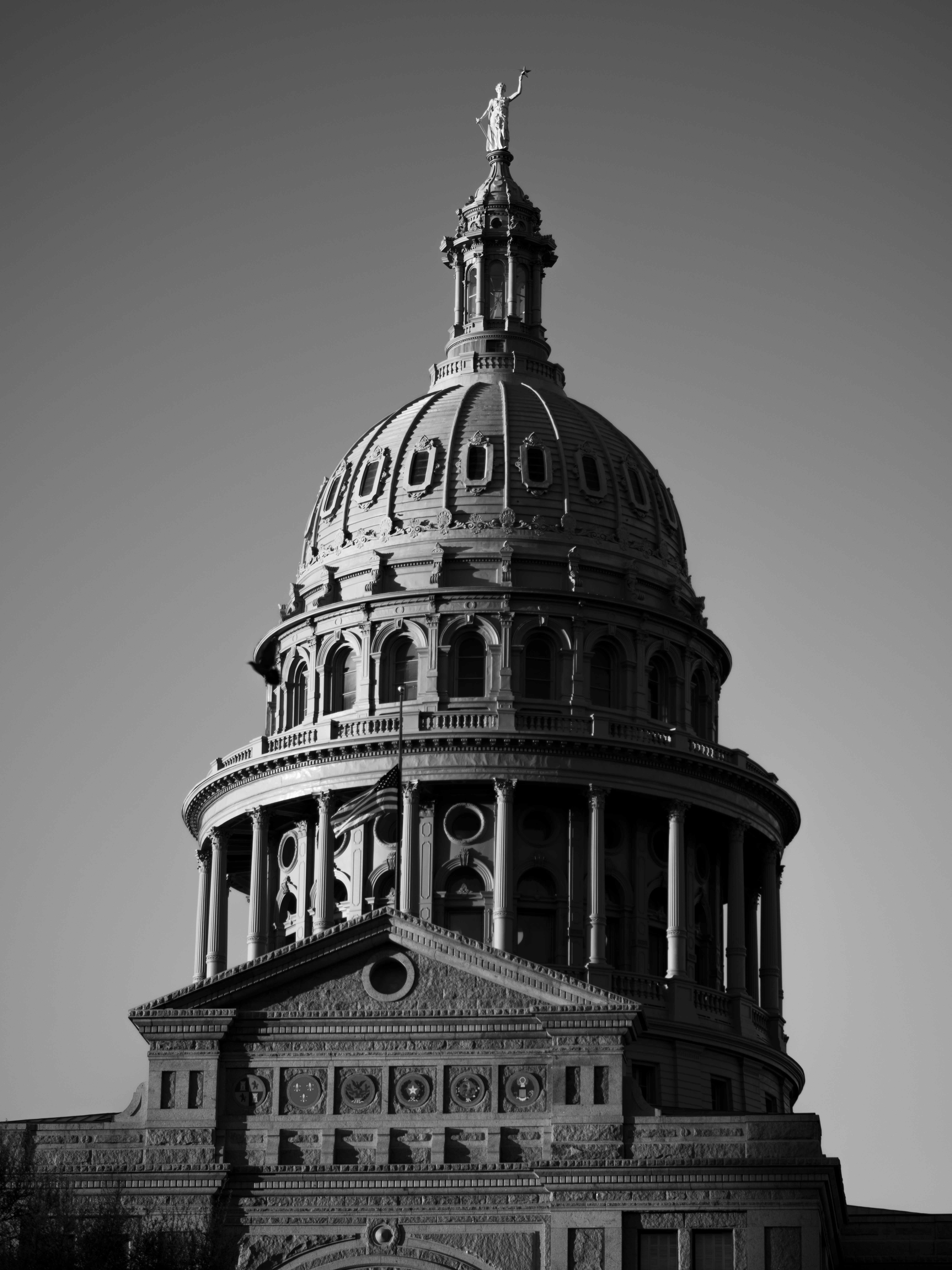 The dome of the Texas State Capitol, in black and white, with a gradient filter creating a gloomy aura about it.